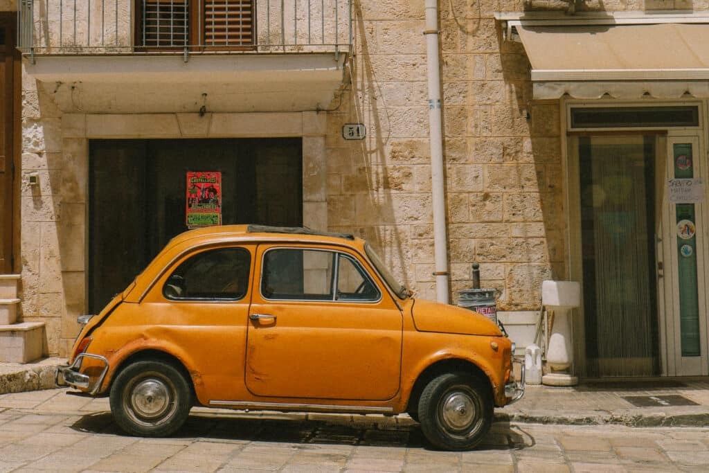 an orange car parked on a street in puglia