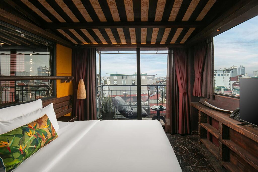 Luxury hotel room in Hanoi with balcony view of the city.