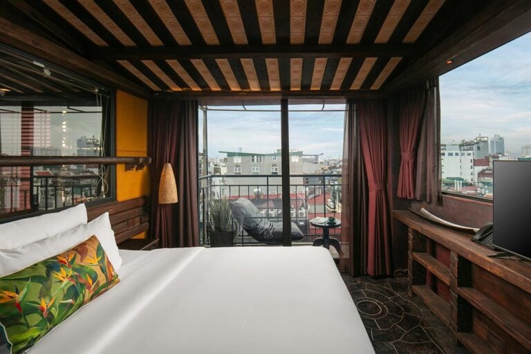 Luxury hotel room in Hanoi with balcony view of the city.