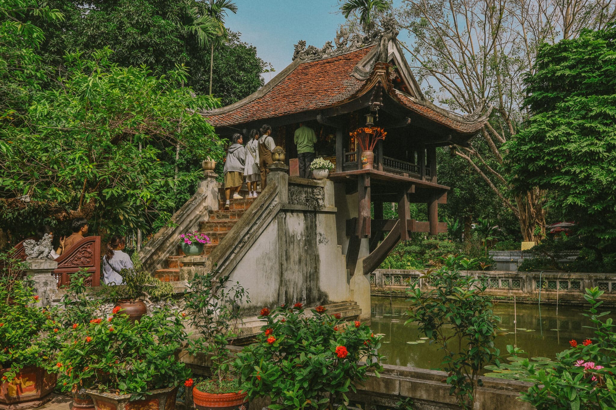 One Pillar Pagoda, a Hanoi hidden gem, with visitors ascending the steps. A unique temple on a pond.