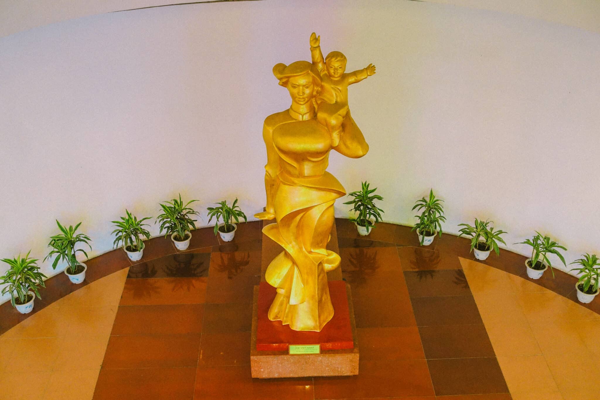 Golden statue of a mother and child in a Hanoi museum.