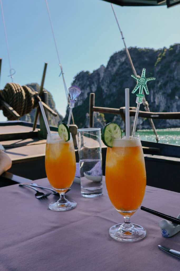 Orange drinks with cucumber on a table during a private Ha Long Bay cruise on L'Amour Junk.