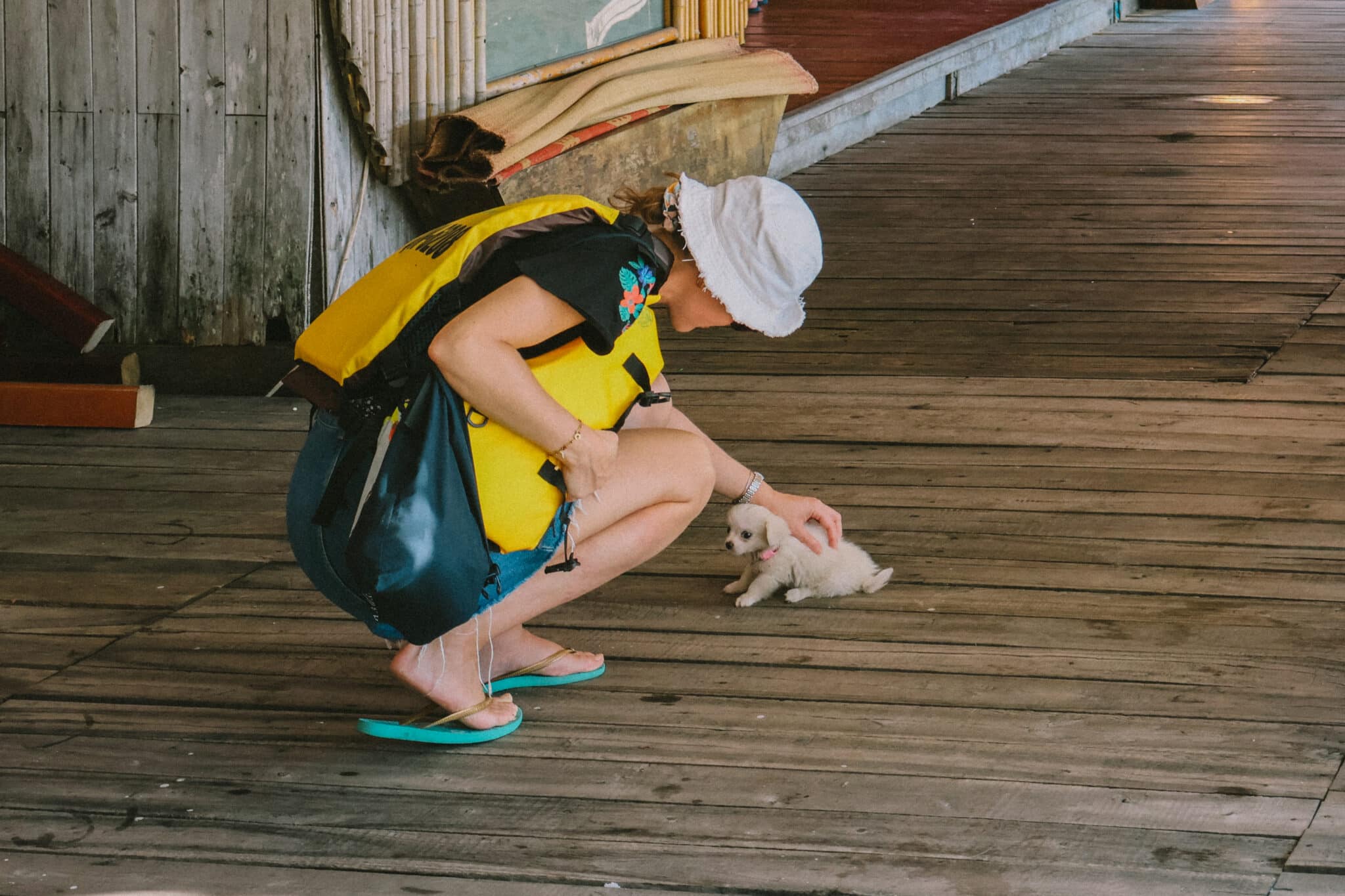 Woman in life vest petting puppy on L'Amour Junk, private Ha Long Bay cruise