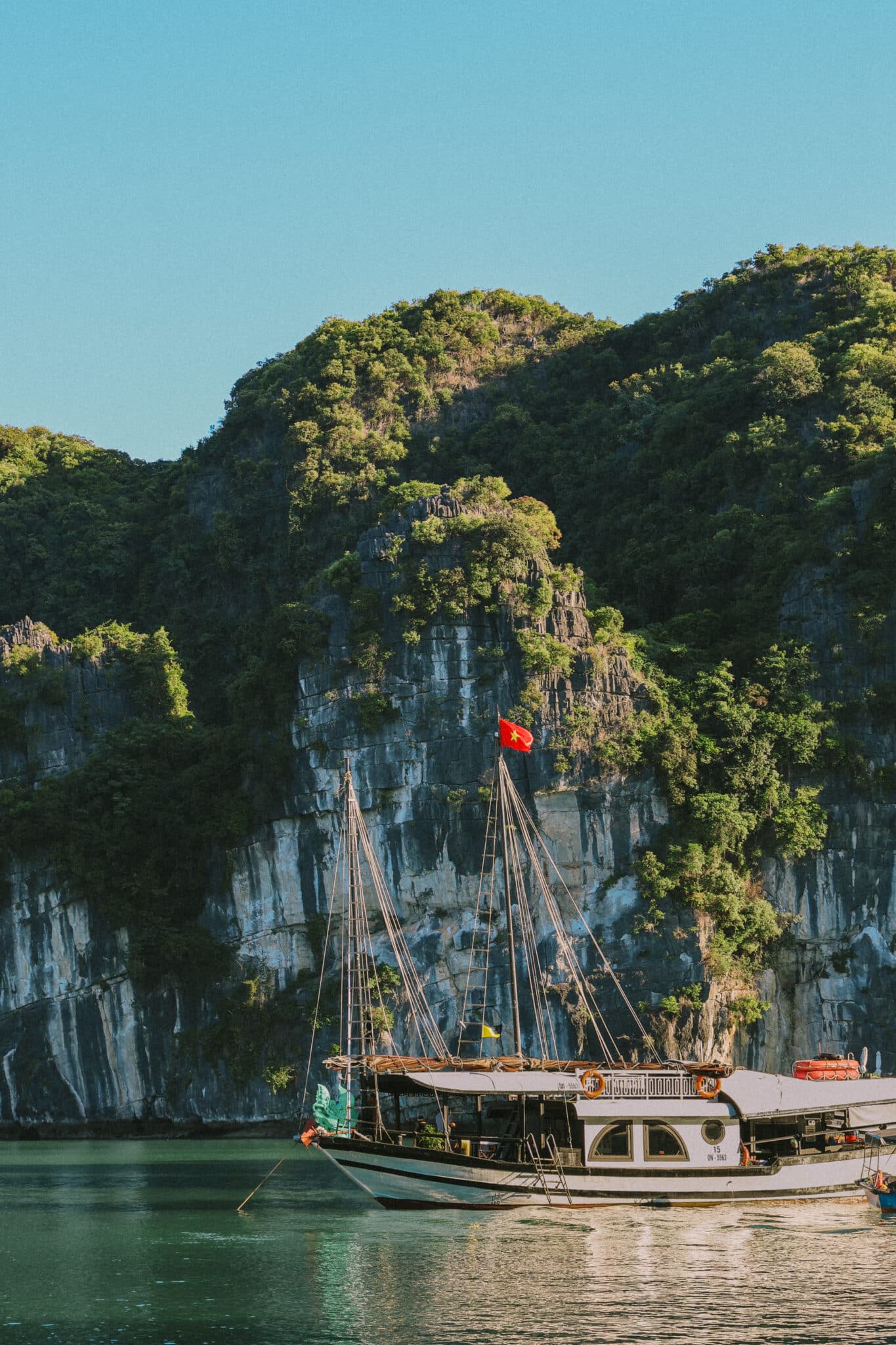 L'Amour Junk, a luxury Ha Long Bay cruise boat, sails past limestone karsts.