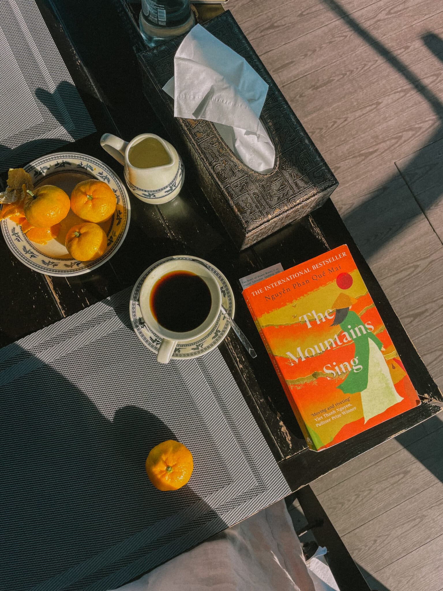 Book "The Mountains Sing" and coffee on a table, on a L'Amour Junk cruise.