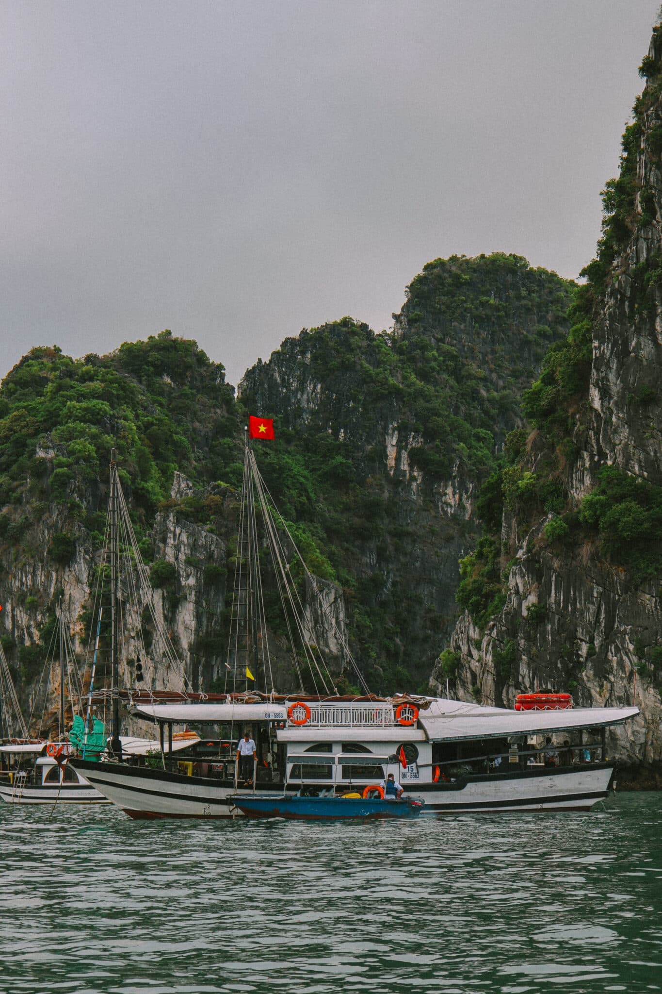 L'Amour Junk, a luxury Ha Long Bay cruise boat, sails past limestone karsts on a private Ha Long Bay cruise.