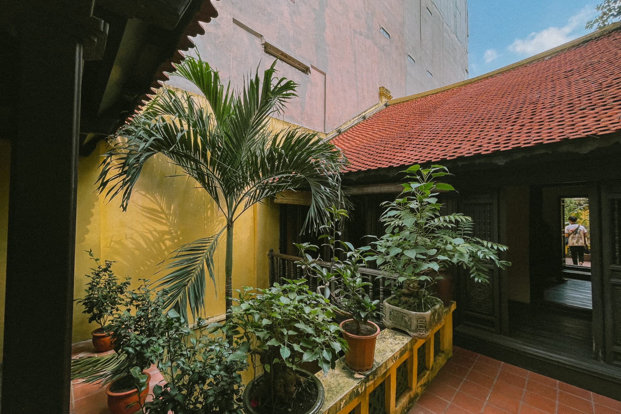 Courtyard of a traditional house in Hanoi's Old Quarter with potted plants.