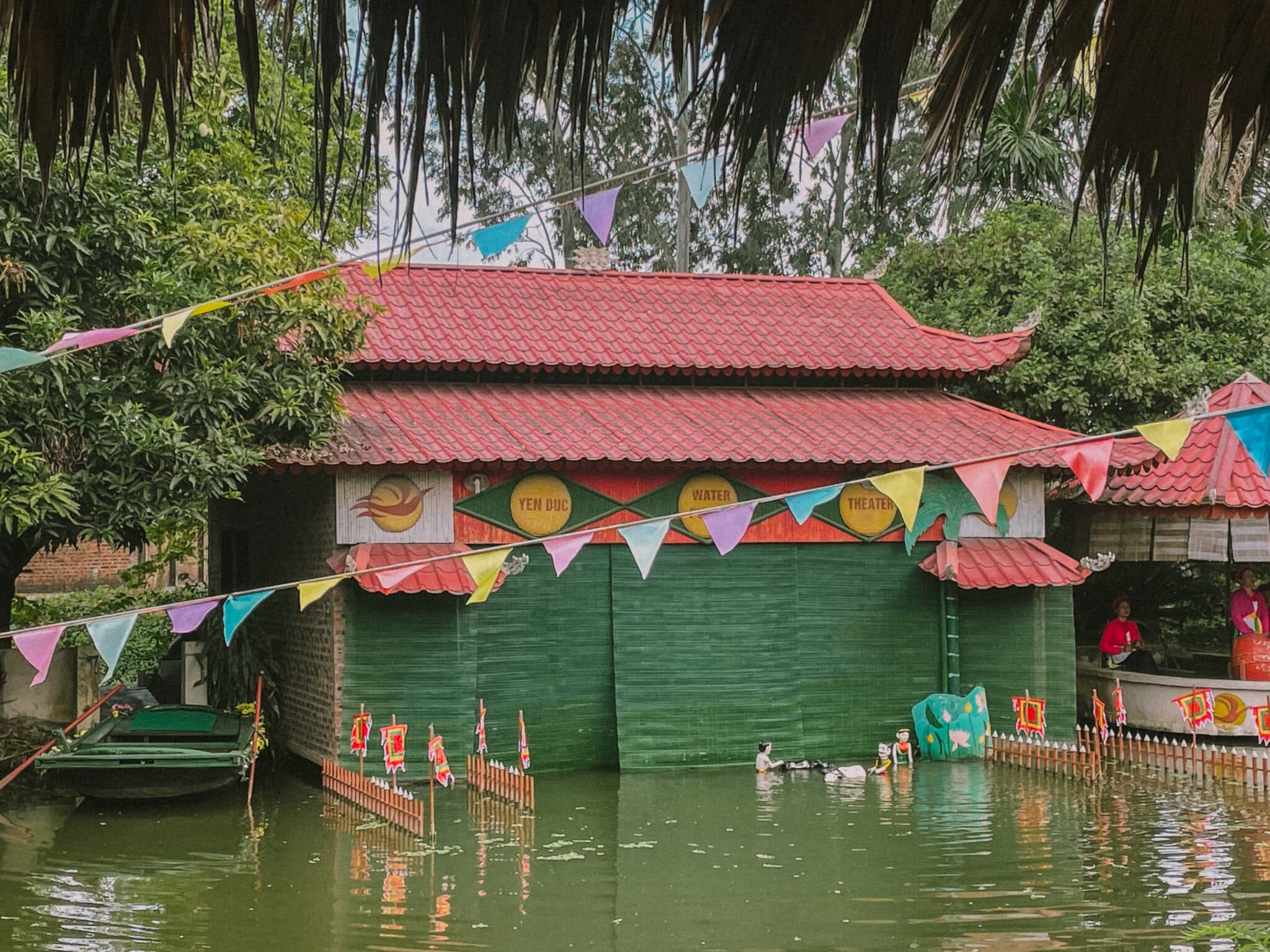Water puppet theater in Hanoi Old Quarter with colorful flags and ducks