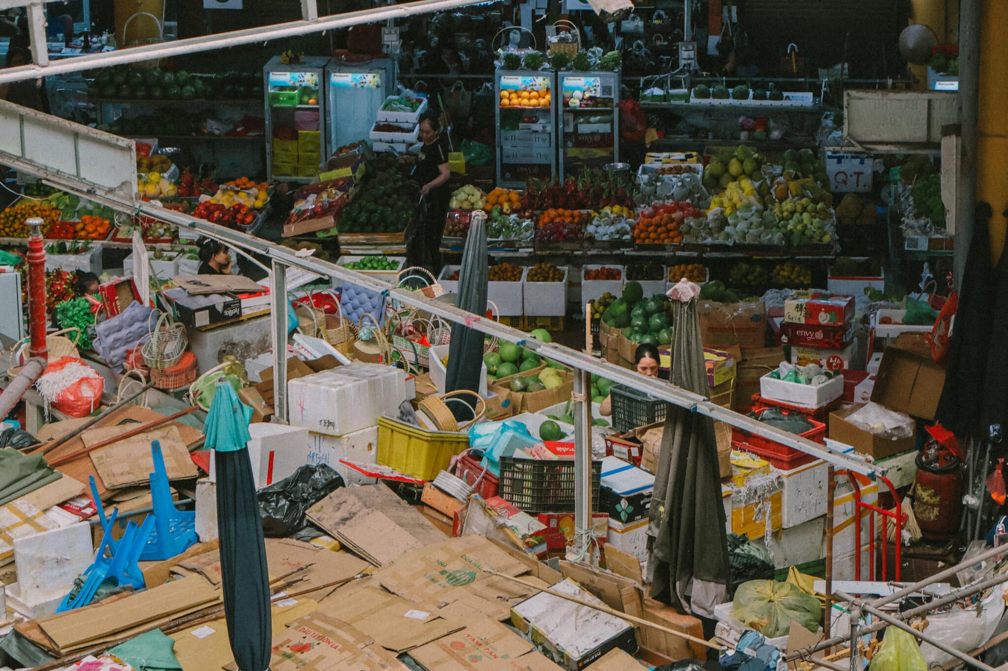 Bustling market stall in Hanoi's Old Quarter with fresh produce and goods
