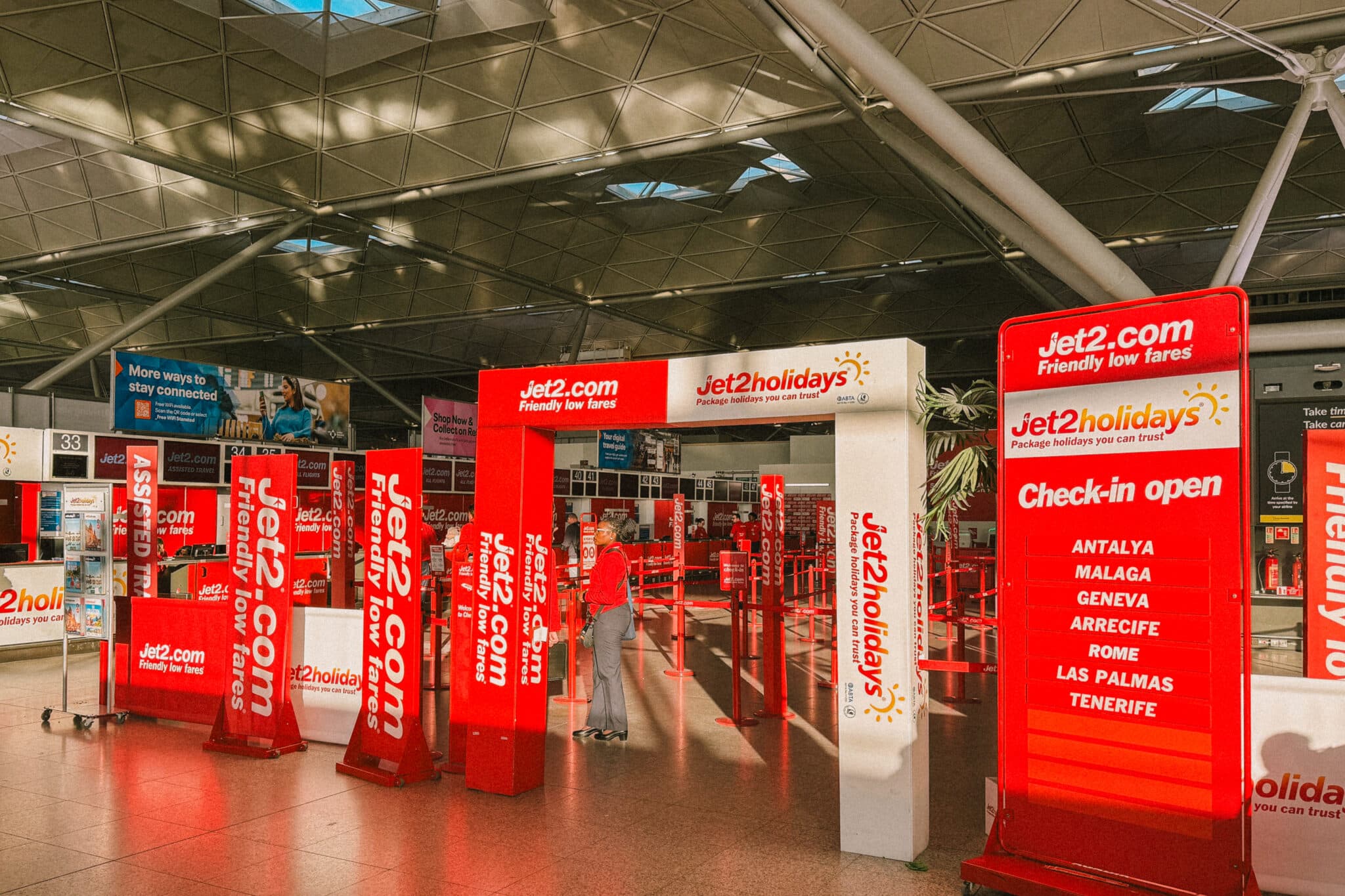 Jet2.com check-in area with signs for Antalya, Malaga, Geneva, Arrecife, Rome, and Las Palmas.
