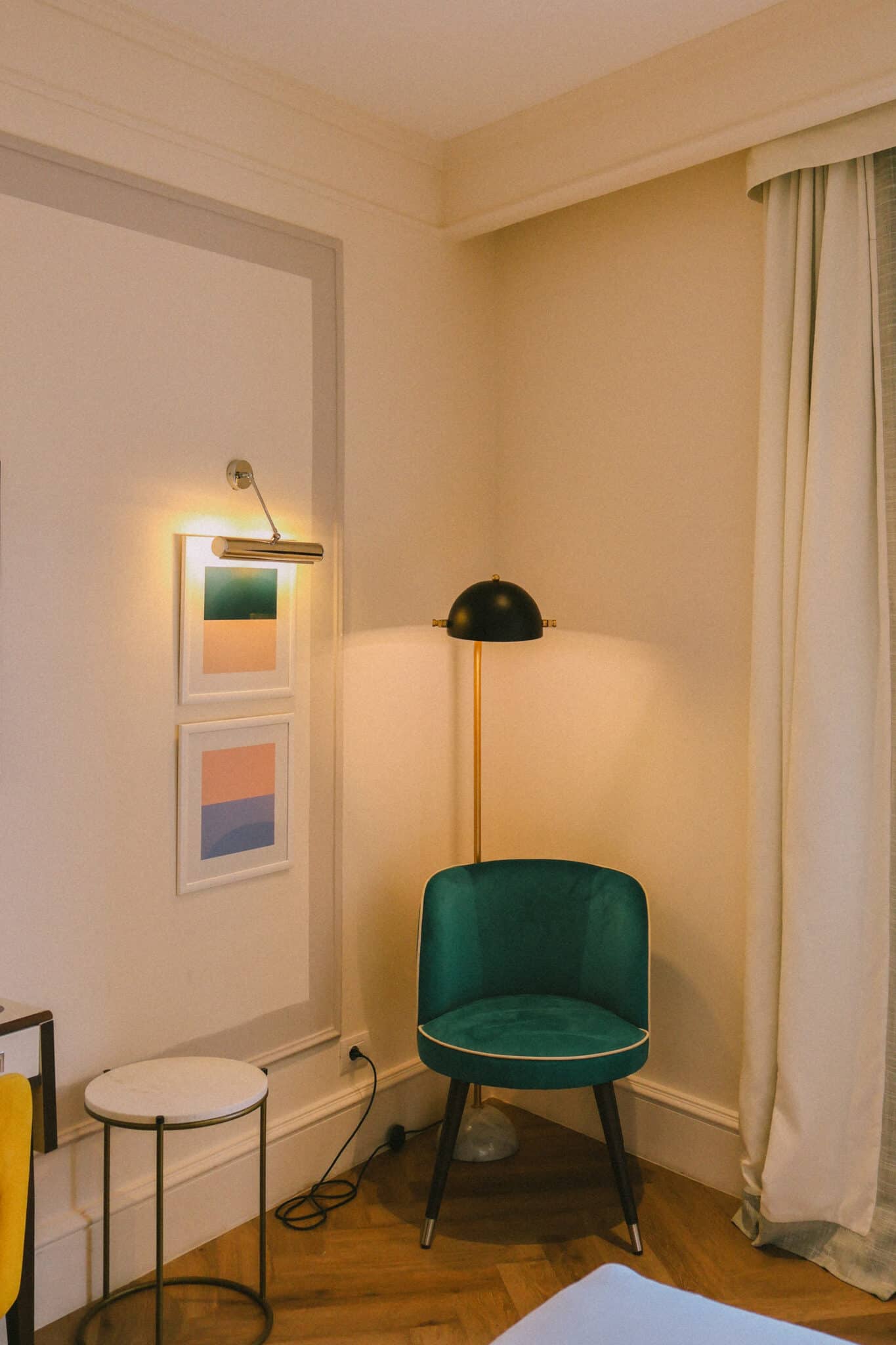 Hotel room corner with green chair, lamp, and artwork in Rome. Jet2CityBreak.