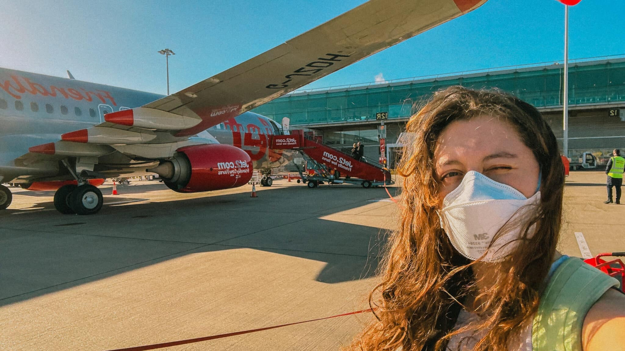 Rachel squints at camera near a Jet2 plane on a Jet2CityBreak to Rome.