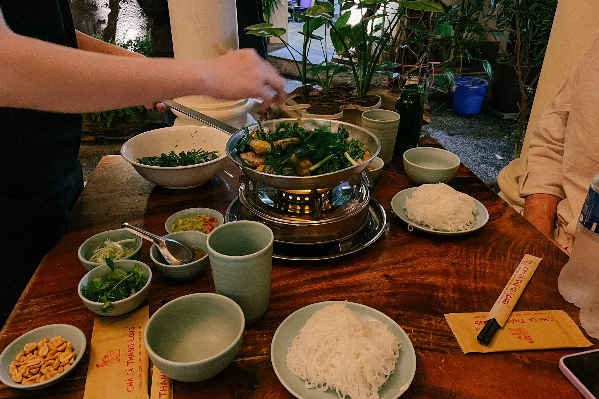 Cha Ca Thang Long in Hanoi: restaurant table with hot pot, noodles, and peanuts.