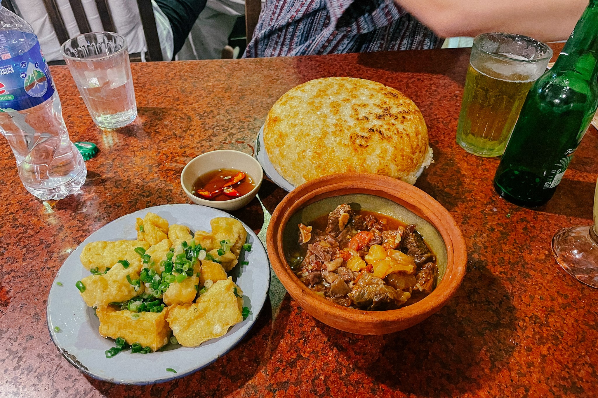 Hanoi street food: Crispy fried tofu, savory beef stew, and a large rice cake