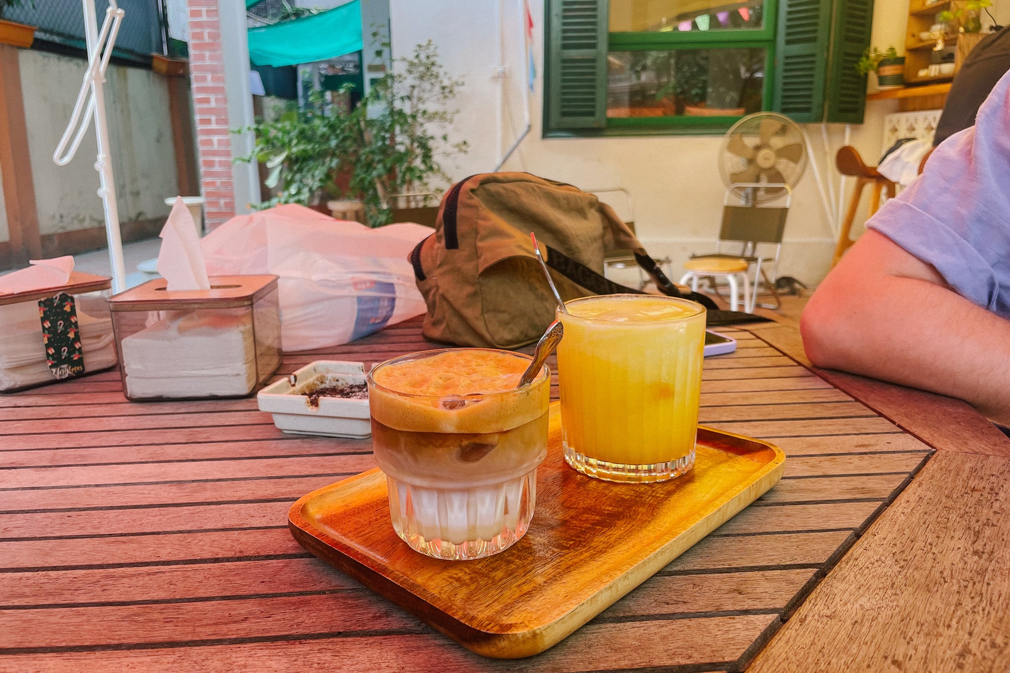 Coffee and juice on a tray at a Hanoi cafe, part of where to eat in Hanoi.