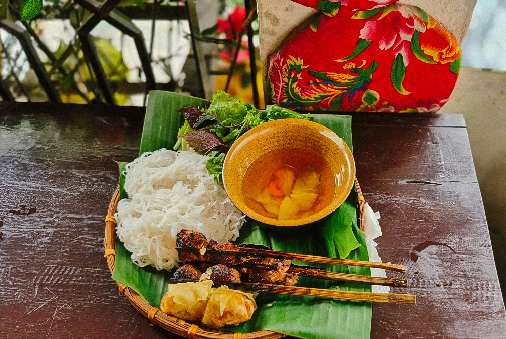 Vietnamese bun cha with grilled pork skewers, rice noodles, and herbs in Hanoi at Bun Cha Hang Quat