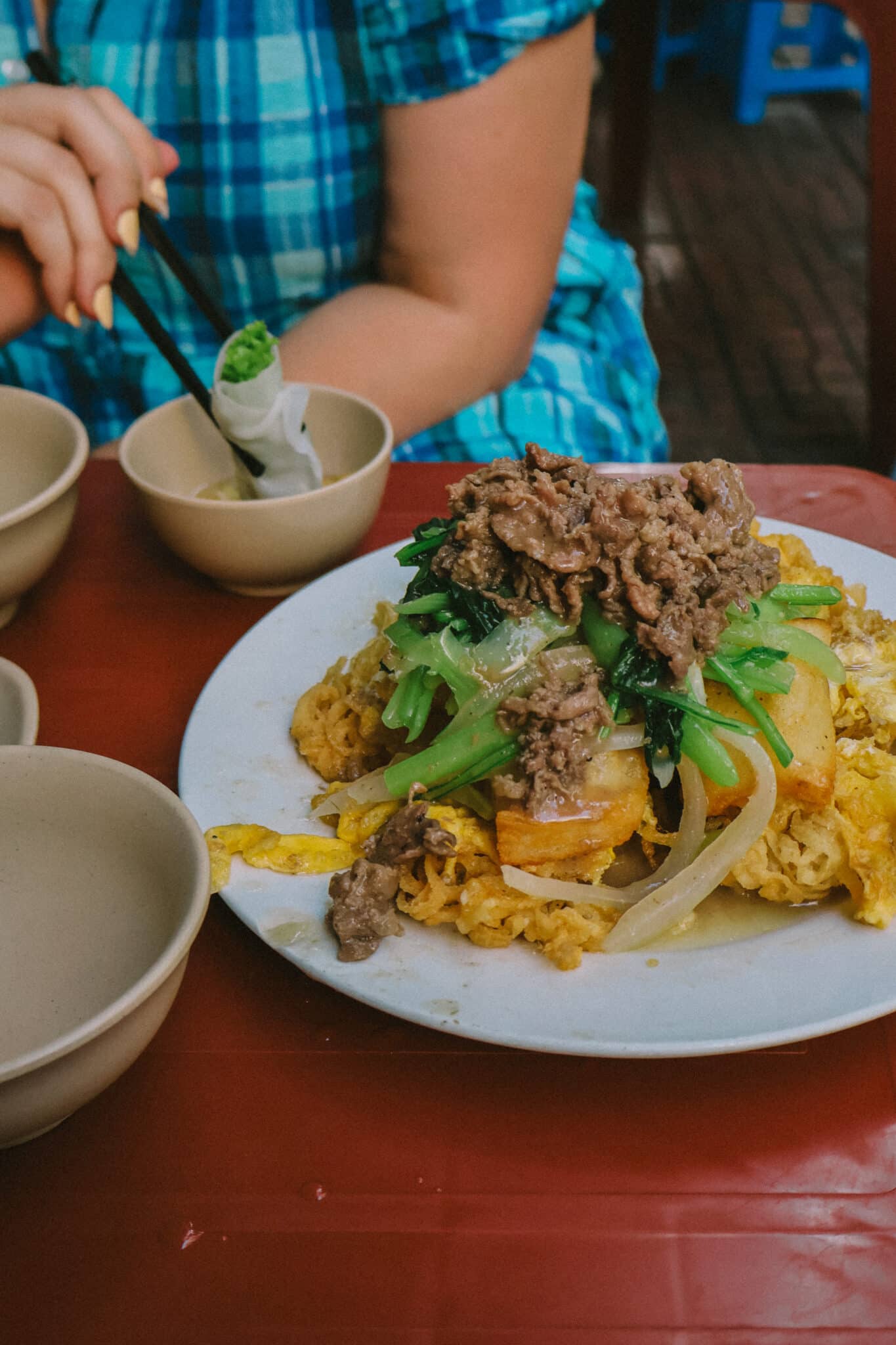 Hanoi street food: Pho chien phong: scrambled eggs with beef and greens over fried pho noodles at a Hanoi restaurant