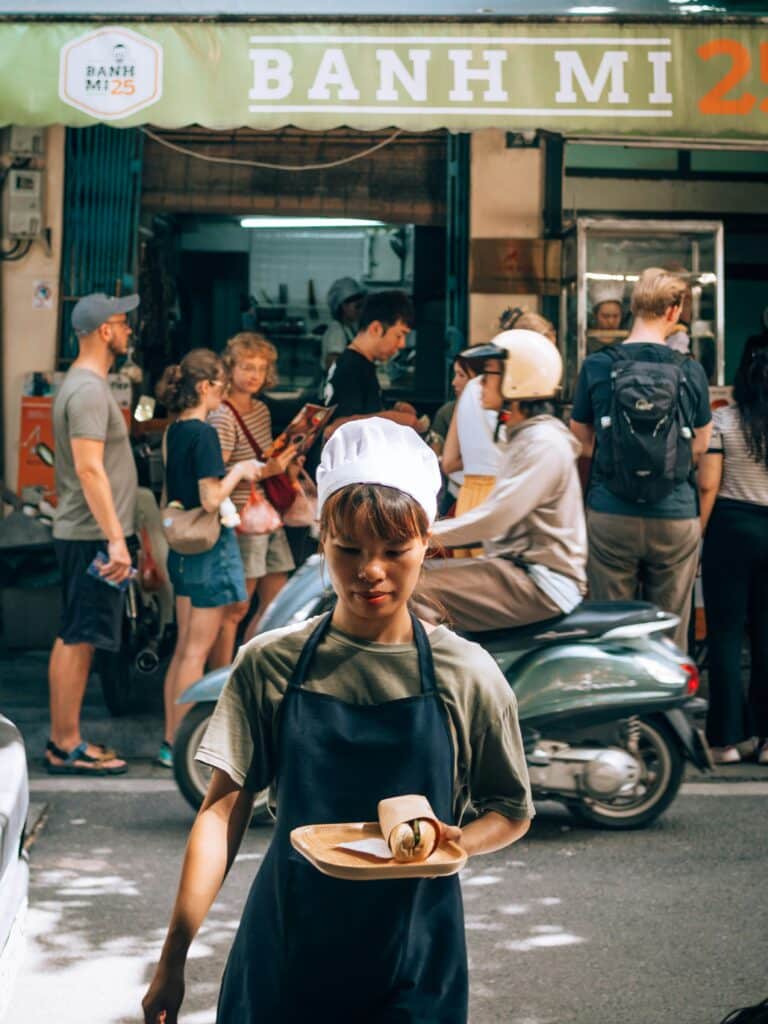 Banh Mi 25 street food vendor in Hanoi, Vietnam, serving banh mi sandwiches.